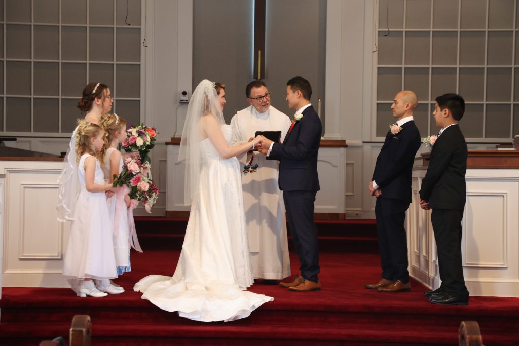 Braut und Bräutigam tauschen vor dem Altar die Ringe aus